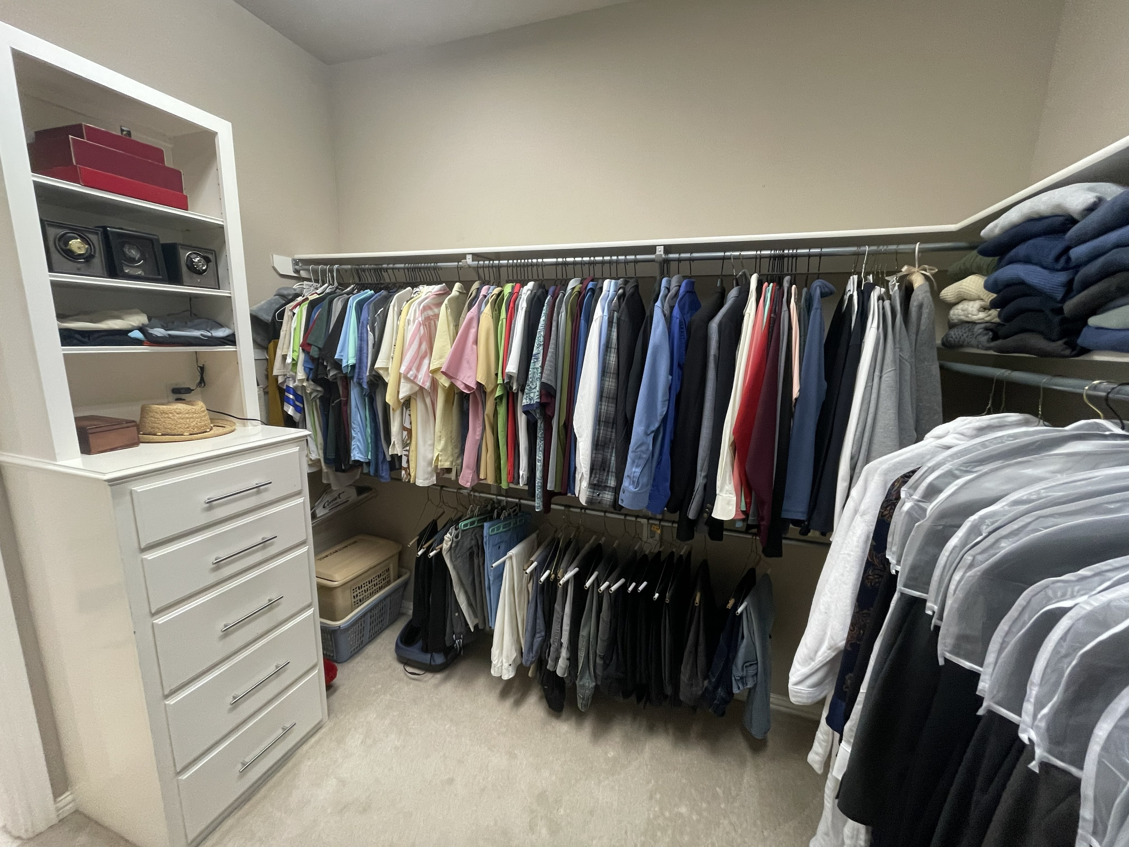 Organized closet with neatly hung clothing sorted by type
