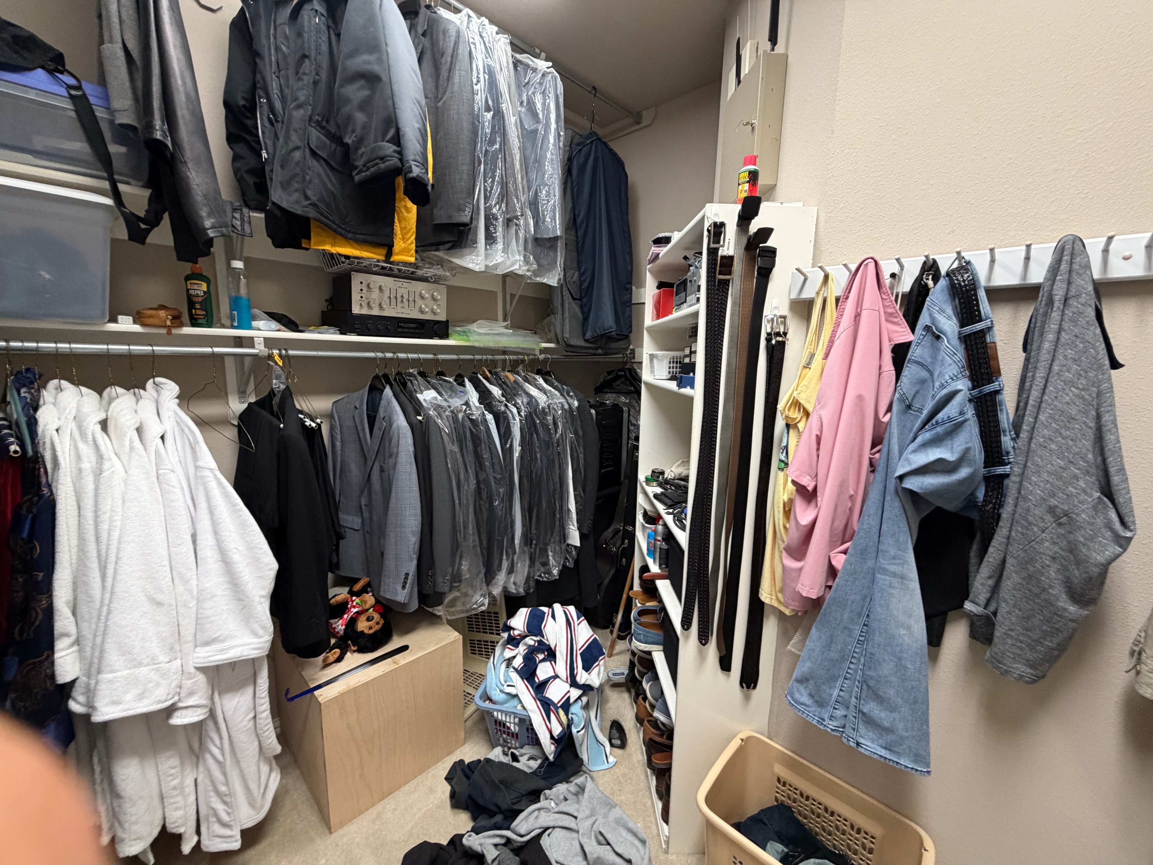 Closet corner with suits, robes, and clothes piled on the floor