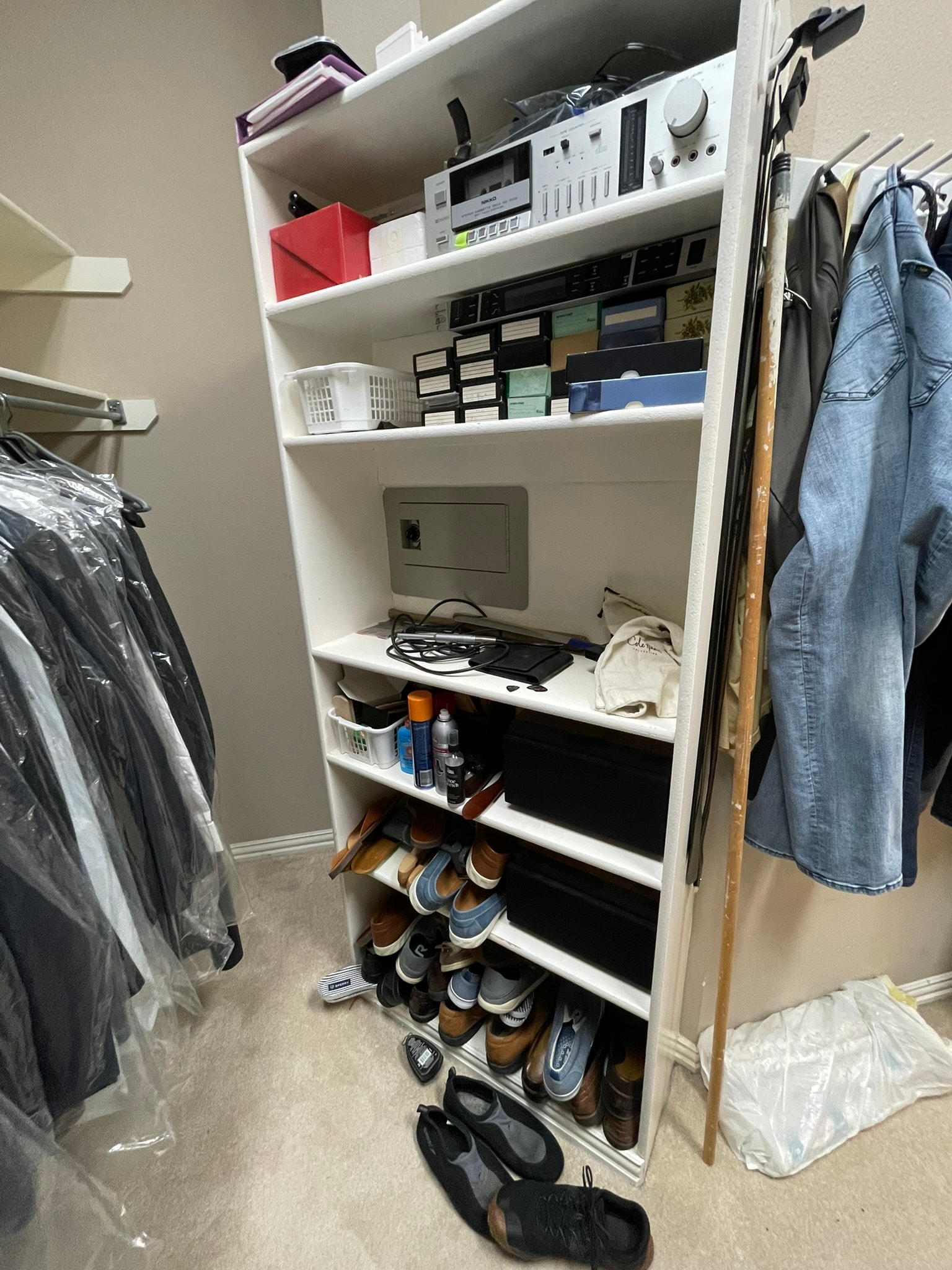 Shelving unit overflowing with shoes, electronics, and miscellaneous items